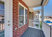 Thumbnail 24 of 32 - A red brick house with a white door and a white railing.