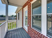 Thumbnail 23 of 32 - A house with a red brick wall and a white window.