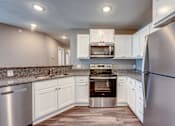 Thumbnail 2 of 32 - A modern kitchen with stainless steel appliances and white cabinets.