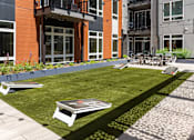 Thumbnail 18 of 46 - A lawn with a frisbee and a table and chairs set up on it.