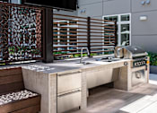 Thumbnail 19 of 46 - A modern outdoor kitchen with a grill and sink.