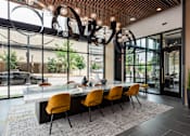 Thumbnail 20 of 46 - A modern dining room with a glass table and orange chairs.