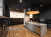 Thumbnail 34 of 46 - A modern kitchen with a wooden floor and a black ceiling light.