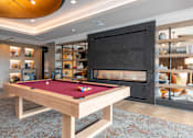 Thumbnail 27 of 46 - A pool table with a red cloth and a fireplace in the background.