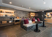 Thumbnail 26 of 46 - A modern living room with a grey sofa and a black coffee table.