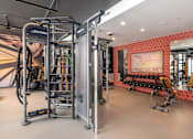 Thumbnail 32 of 46 - A gym with a red wall and a mirror.