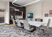 Thumbnail 40 of 46 - A conference room with a white table and grey chairs.