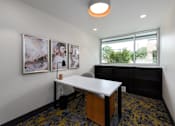 Thumbnail 41 of 46 - A white desk with a black chair in a room with a window.