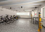 Thumbnail 42 of 46 - A room with a row of bicycles and a yellow pole.