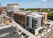Thumbnail 44 of 46 - A modern building with a parking lot in front.