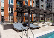 Thumbnail 17 of 46 - A pool area with a pergola and lounge chairs.