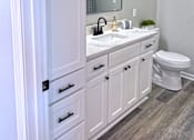 Thumbnail 8 of 18 - A white bathroom with a toilet, sink, and mirror.