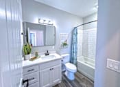 Thumbnail 17 of 18 - A white bathroom with a toilet, sink, and mirror.