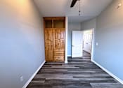 Thumbnail 11 of 18 - A room with a wooden door and a ceiling fan.