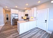 Thumbnail 1 of 18 - A kitchen with white cabinets and a refrigerator.