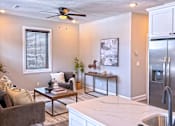 Thumbnail 3 of 18 - A modern kitchen with a brown sofa and a ceiling fan.