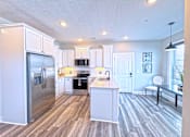 Thumbnail 4 of 18 - A kitchen with a refrigerator, microwave, oven, and sink.