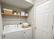 Thumbnail 9 of 19 - A white bathroom with a double sink and a white door.