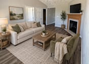 Thumbnail 5 of 19 - A living room with a couch, coffee table, and a fireplace.