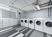 Thumbnail 40 of 42 - a row of washers and dryers in a laundry room at Clayton On The Park, Clayton
