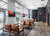 Thumbnail 36 of 42 - a lobby with leather chairs and a table in front of large windows at Clayton On The Park, Missouri, 63105
