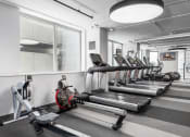 Thumbnail 27 of 42 - a row of cardio machines in a gym at Clayton On The Park, Clayton, 63105