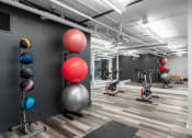 Thumbnail 26 of 42 - a gym with exercise equipment and exercise balls and weights at Clayton On The Park, Clayton
