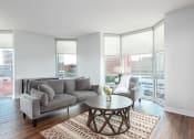 Thumbnail 7 of 42 - a living room with a couch and a coffee table and large windows at Clayton On The Park, Clayton, 63105