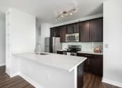 Thumbnail 1 of 42 - an empty kitchen with a large white counter top at Clayton On The Park, Clayton, Missouri