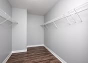 Thumbnail 12 of 42 - spacious walk in closet with white walls and shelves and wood flooring at Clayton On The Park, Clayton, 63105