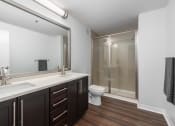 Thumbnail 15 of 42 - a bathroom with a large mirror and a toilet and a shower at Clayton On The Park, Clayton, MO