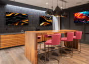 Thumbnail 20 of 42 - a kitchen with a bar and chairs and paintings on the wall at Clayton On The Park, Missouri, 63105