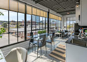 Thumbnail 29 of 39 - Steelcote Crossing living area with dinning room table and oversized windows at Steelcote Square, St. Louis