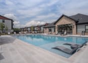 Thumbnail 1 of 28 - Pool with a clubhouse behind at The Junction at Rogers, Rogers, 72756