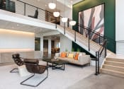 Thumbnail 41 of 71 - a living room with a staircase and a couch and a table at The Flats & Terraces at Wildhorse Village, Chesterfield