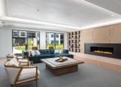 Thumbnail 40 of 71 - a living room with a blue couch and a fireplace at The Flats & Terraces at Wildhorse Village, Chesterfield, 63005