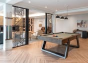 Thumbnail 37 of 71 - a billiards table in a living room with a glass door at The Flats & Terraces at Wildhorse Village, Missouri, 63005