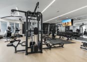 Thumbnail 34 of 71 - a gym with weights and other exercise equipment on the floor at The Flats & Terraces at Wildhorse Village, Chesterfield, Missouri