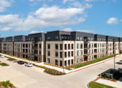 Thumbnail 45 of 71 - an aerial view of a row of apartment buildings on a city street at The Flats & Terraces at Wildhorse Village, Chesterfield, Missouri