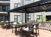 Thumbnail 28 of 71 - a patio with tables and chairs under an awning at The Flats & Terraces at Wildhorse Village, Chesterfield