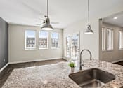 Thumbnail 2 of 23 - A kitchen with a granite countertop and a window view.