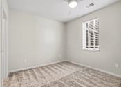 Thumbnail 17 of 23 - A room with a carpeted floor and a window with blinds.
