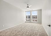 Thumbnail 21 of 23 - A room with a carpet floor and a ceiling fan.