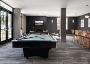 Thumbnail 11 of 28 - Hibernia resident lounge with pool table, large TV, and built-in fireplace at Hibernia Apartments, St Louis