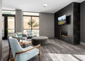 Thumbnail 10 of 28 - Hibernia resident lounge with large TV, built-in fireplace and conversational seating at Hibernia Apartments, St Louis, Missouri
