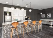 Thumbnail 12 of 28 - a kitchen with bar stools and a counter top in a living room at Hibernia Apartments, St Louis, 63139