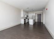 Thumbnail 3 of 28 - Hibernia living room with rich vinyl plank flooring opening to kitchen at Hibernia Apartments, St Louis, 63139
