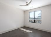 Thumbnail 5 of 28 - Hibernia bedroom with rich vinyl plank flooring, oversized windows with white blinds and ceiling fan at Hibernia Apartments, St Louis, Missouri