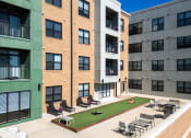 Thumbnail 26 of 28 - Hibernia resident amenity deck with gaming turf, conversational seating and grilling station at Hibernia Apartments, St Louis, MO, 63139