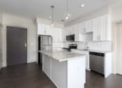 Thumbnail 1 of 28 - Hibernia kitchen with white cabinets, white tile backsplash, granite countertops and stainless steel appliances at Hibernia Apartments, St Louis, MO, 63139